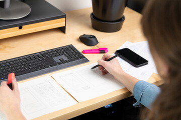Wall Mural - Sketch of wireframe for website. Women designer working on a mobile application, drawing on paper.