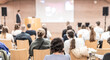 © kasto - Speaker giving a talk in conference hall at business event. Rear view of unrecognizable people in audience at the conference hall. Business and entrepreneurship concept