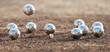 Petanque ball boules bowls on a dust floor, photo in impact. Game of petanque on the ground. Balls and a small wood jack