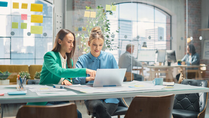 Poster - Portrait of Two Creative Colleagues Collaborating and Pointing at the Laptop in Modern Office. Female Manager Consults White Project Manager, They Brainstorm on the Project.