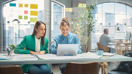 Poster - Two Creative Colleagues Discussing and Pointing at a Laptop in Modern Casual Office. Caucasian Sales Manager Discussing Project Plan with Female Legal Assistant and Taking Notes