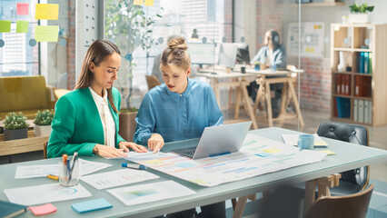 Poster - Two White Females Have a Discussion in Meeting Room Behind Glass Walls in an Agency. Creative Director and Project Manager Compare Business Results and App Designs on Laptop in an Office