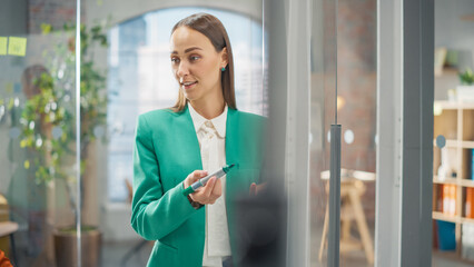 Poster - Portrait of a Young Female Businesswoman Writing on a Whiteboard During a Company Meeting at the Office. Successful Woman Leading an Important Training Workshop for Employees