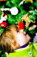 Wall Mural - Amazed portrait of a little girl decorating the Christmas tree