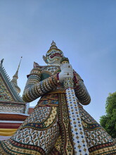 View From Below Of An Ancient Giant Statue Standing At Wat Arun, Bangkok Thailand. White Giant Or Yak Guardian The Temple Of Dawn.Its Among The Best Known Of Landmarks.

