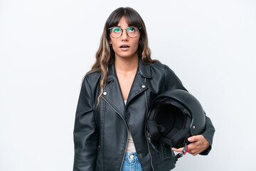 Wall Mural - Young caucasian woman with a motorcycle helmet isolated on white background looking up and with surprised expression