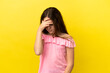 Little caucasian girl isolated on yellow background with headache