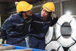 © chachamp - Technician engineer African American woman helping friend for accident with metal sheet background at site work