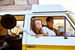 © Roman - Happy beautiful caucasian young woman looking and smiling out of window from old yellow vintage van bus, in countryside. travel driving concept for cute attractive pretty female with long hair.