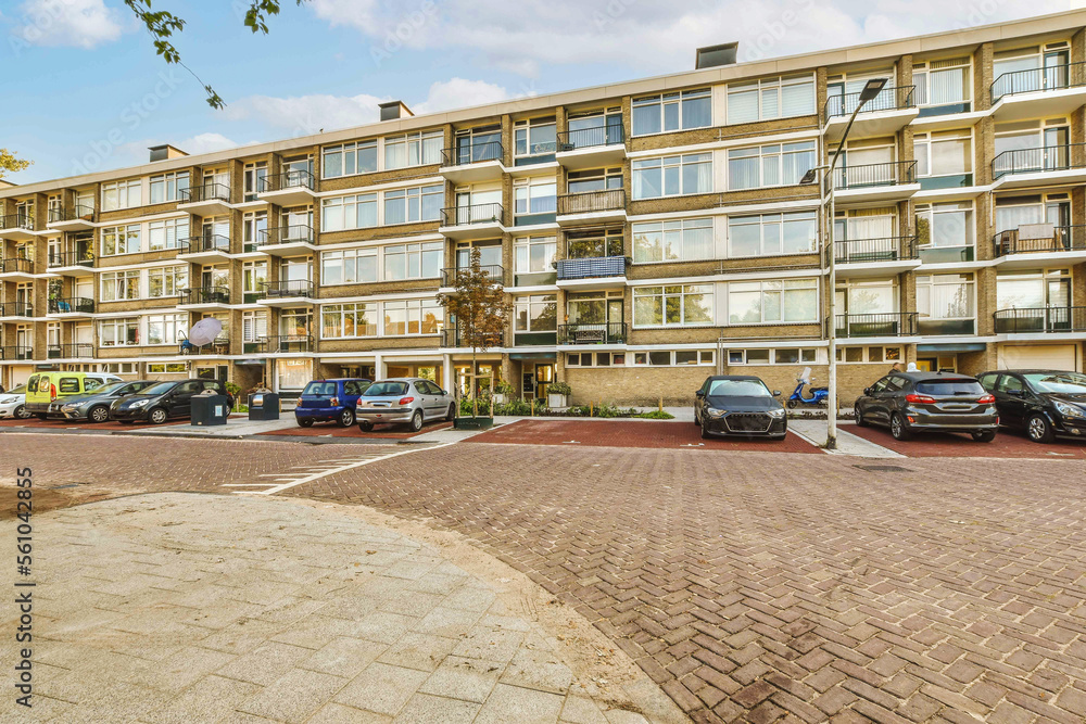 an apartment complex with cars parked on the street in front of thema's ...