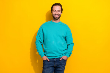 Wall Mural - Photo of satisfied smiling glad successful entrepreneur influencer man stubble beard hands denim pockets isolated on yellow color background