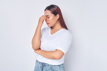 Wall Mural - Tired exhausted sad young woman Asian wearing casual white t-shirt keep eyes closed rub put hand on nose isolated on white background. Healthy lifestyle ill sick disease treatment concept
