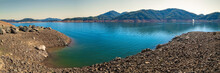 Shasta Lake At Low Water Level With The Gravel Lake Bed Exposed In The Sacramento River, Northern California, United States, Panoramic Landscape With Curving Water’s Edge