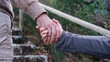 © Rebeca Vidal - Hombre dándole la mano a su mujer para ayudarle a subir la montaña. Pareja de ancianos enamorados ayudándose