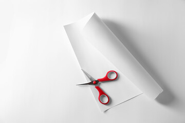 Wall Mural - Red scissors and paper on white background, top view. Space for text