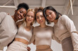 © Roman - Bottom view on four smiling multiracial women with different types of skin, ethnicity. Caucasian, Black american and Asian models in studio, have fun.Beautiful young women with natural make-up.