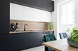 © photosbysabkapl - Interior of kitchen with modern black kitchen furniture, table and chairs and window.