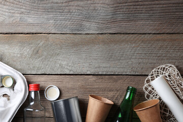 Recycling symbol and garbage on wooden table, flat lay