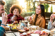 Group of happy friends celebrating at dinner drinking red wine at sunset in backyard - Young people having barbecue party at terrace bar restaurant - Millennial lifestyle concept