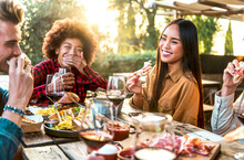 Group Of Happy Friends Celebrating At Dinner Drinking Red Wine At Sunset In Backyard - Young People Having Barbecue Party At Terrace Bar Restaurant - Millennial Lifestyle Concept