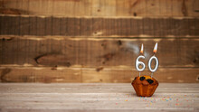 Scenery Festive Wooden Background Happy Birthday Copy Space. Anniversary Background With Number Of Burning Candles And Muffin. Beautiful Brown From Vintage Boards Background Before A Birthday 60