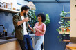 © Wavebreak Media - Cheerful biracial young couple enjoying coffee and talking while standing in kitchen, copy space