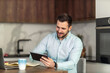 © ivanko80 - Young man using digital tablet in kitchen at home