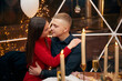 © verona_studio - Romantic couple dating at night in restaurant, cozy atmosphere, beautiful young couple  with glasses of red wine during romantic dinner, Sweet Couple Date Dinner