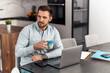 © ivanko80 - Man with papers and laptop computer working at home office