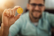 © ivanko80 - Smiling attractive young caucasian guy shows bitcoin to camera