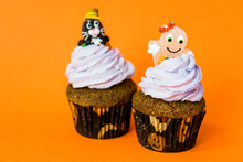 Two Funny Halloween Cupcakes With A Cheshire Cat And A Ghost On Cream