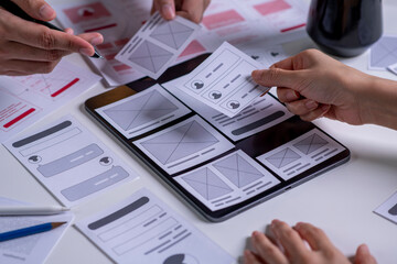close up ux developer and ui designer brainstorming about mobile app interface wireframe design on t