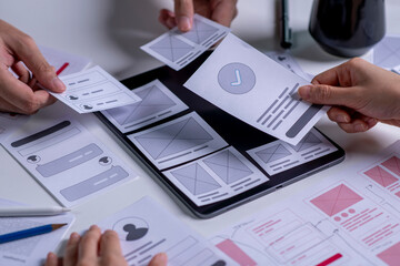close up ux developer and ui designer brainstorming about mobile app interface wireframe design on t