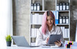 © crizzystudio - Portrait of a young Asian businesswoman working on a tablet with a laptop at the thinking office. analyze marketing data online business ideas.