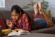 © IndiaPix - Tween girl studying on the couch in living room