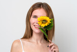Fototapeta Fototapeta Londyn - Young English woman holding a sunflower while smiling. Close up portrait