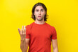 © luismolinero - Caucasian handsome man isolated on yellow background making doubts gesture