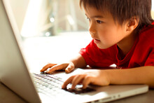 Little Kid Playing On The Laptop.