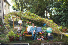Happy Woman On A Vintage Couch In A Garden
