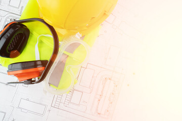 Wall Mural - anti noise headphones, eye protection goggles, reflective vest, worker's uniform on background of architectural drawings, health protection at work