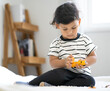 © Nassorn - Cute boy playing car toy. Young male kid toddler happy play with vehicle toy at home. Asian preschool little child sitting have fun with plaything. Playing is learning and creativity imagination.