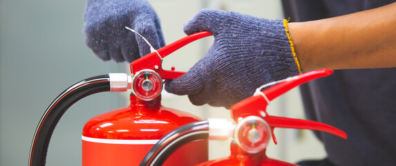 Wall Mural - Fire extinguisher has hand engineer inspection checking pressure gauges to prepare fire equipment for protection and prevent in emergency case and safety or rescue and alarm system training concept.