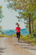 © .shock - Young happy woman enjoying in a healthy lifestyle while jogging on a country road through the beautiful sunny forest, exercise and fitness concept