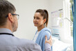 © Austockphoto - Male doctor placing his hand on his female patient's shoulder, reassuring her