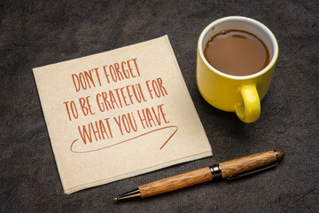 do not forget to be grateful for what you have - inspirational advice or reminder on an a napkin with coffee