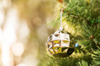 © Austockphoto - Golden Christmas bauble with bokeh copy space