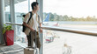 A young asian man  with suitcase , check in at International airport , vacation travel and transportation concept