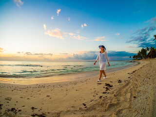 Wall Mural - Woman walking on sunny, tropical beach at daybreak
