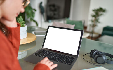 Over shoulder view of woman student elearning looking at white mock up blank screen using laptop computer learning online, remote working concept. Website mockup display template for ads concept