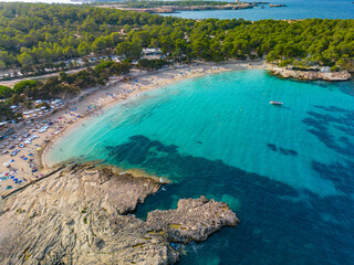 Ibiza Cala Bassa beach with turquoise water, aerial views